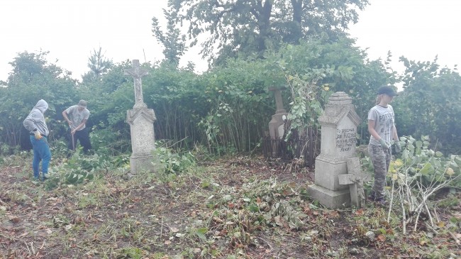 Wolontariusze przy pracach na cmentarzu w Tuligłowach