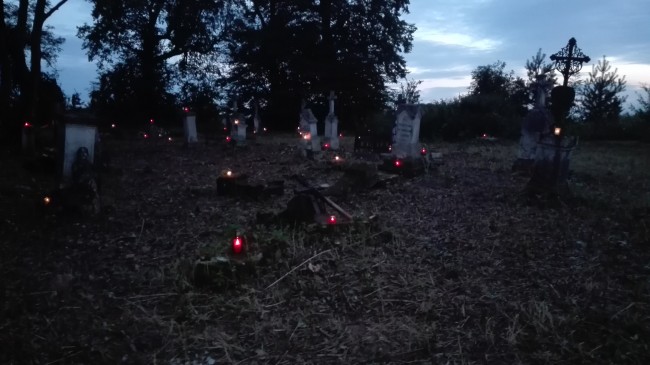 Płonące znicze na cmentarzu w Tuligłowach